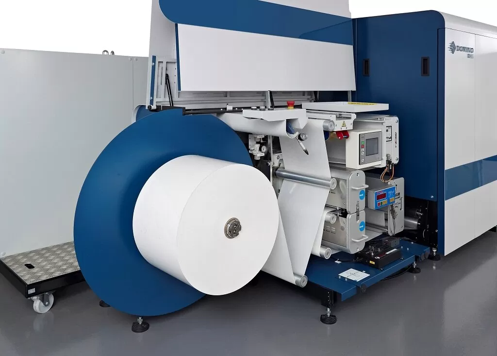 Paper converting production machine processing a large tissue roll